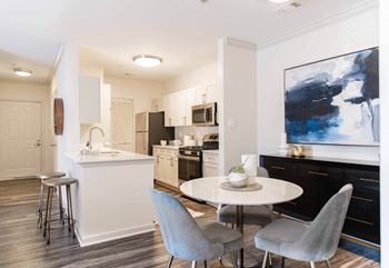 a living room with a kitchen and a table and chairs at The Residences at Springfield Station, Springfield